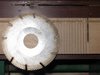 Пильный диск отдельно. На заднем плане гребенка из липы с двумя паралельными пропилами.